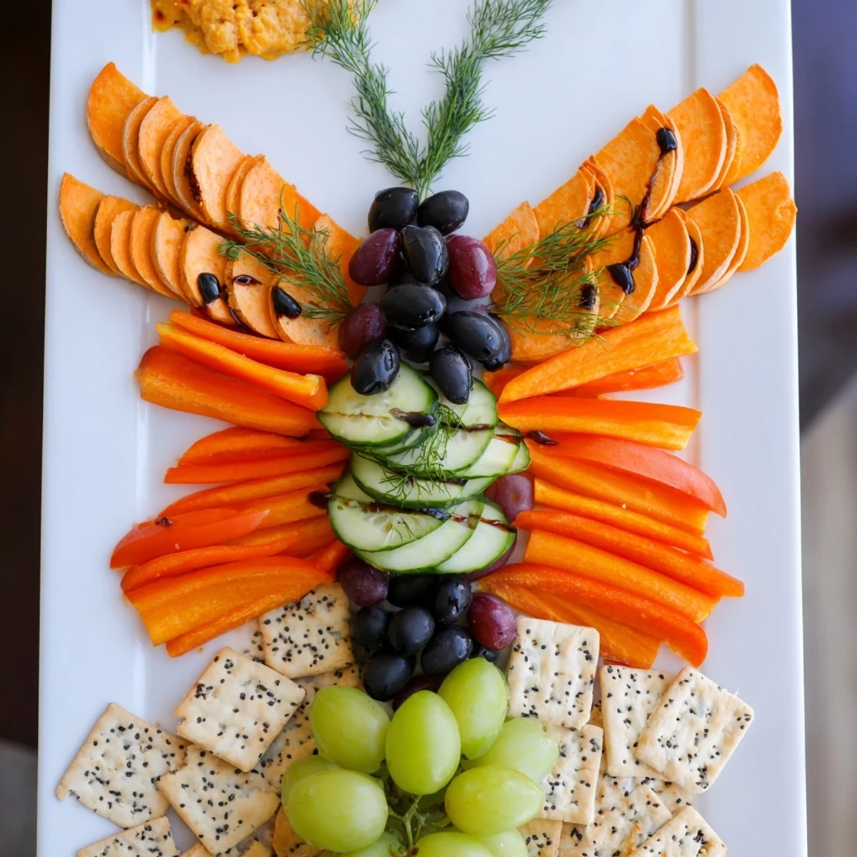 A colorful platter of Monarch Butterfly Wings appetizer with vibrant orange and black ingredients.