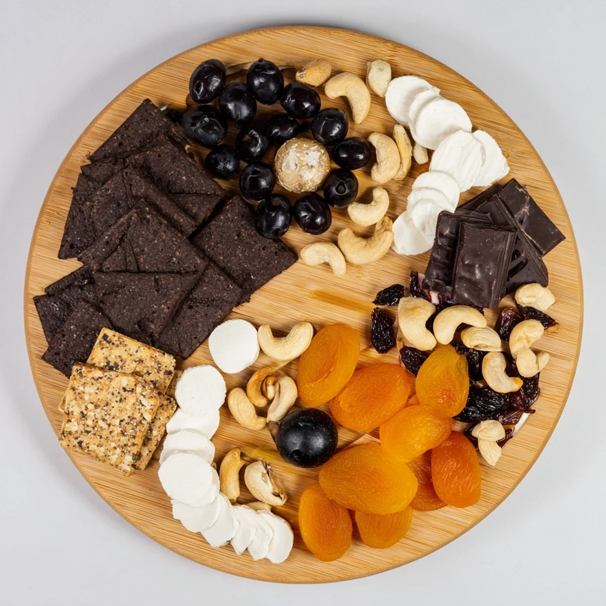 Visual platter of Yin and Yang Balance Board: Dark olives and white cheese showcase a striking contrast.