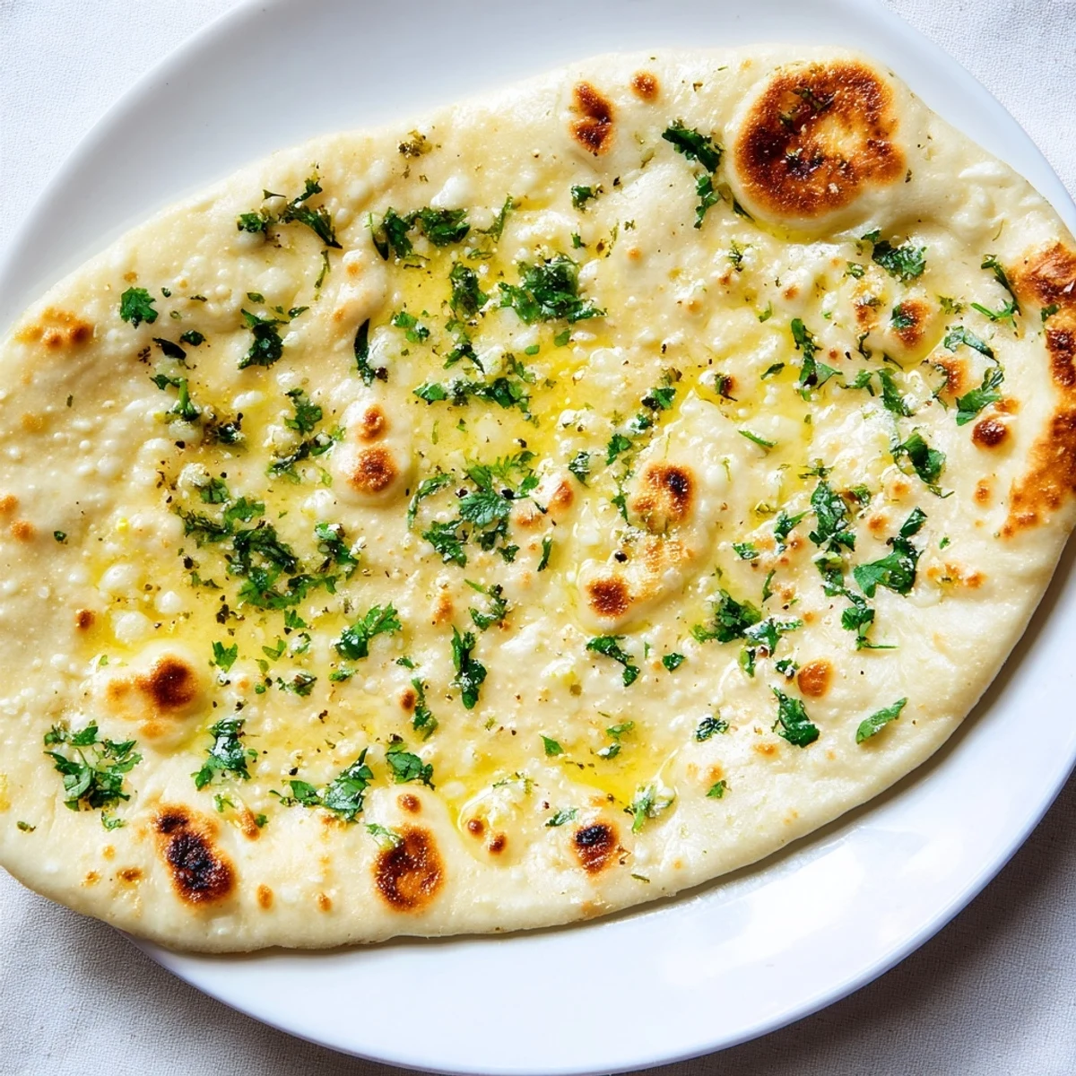 Warm homemade garlic naan bread brushed with glistening butter, ready to serve with fragrant curry.