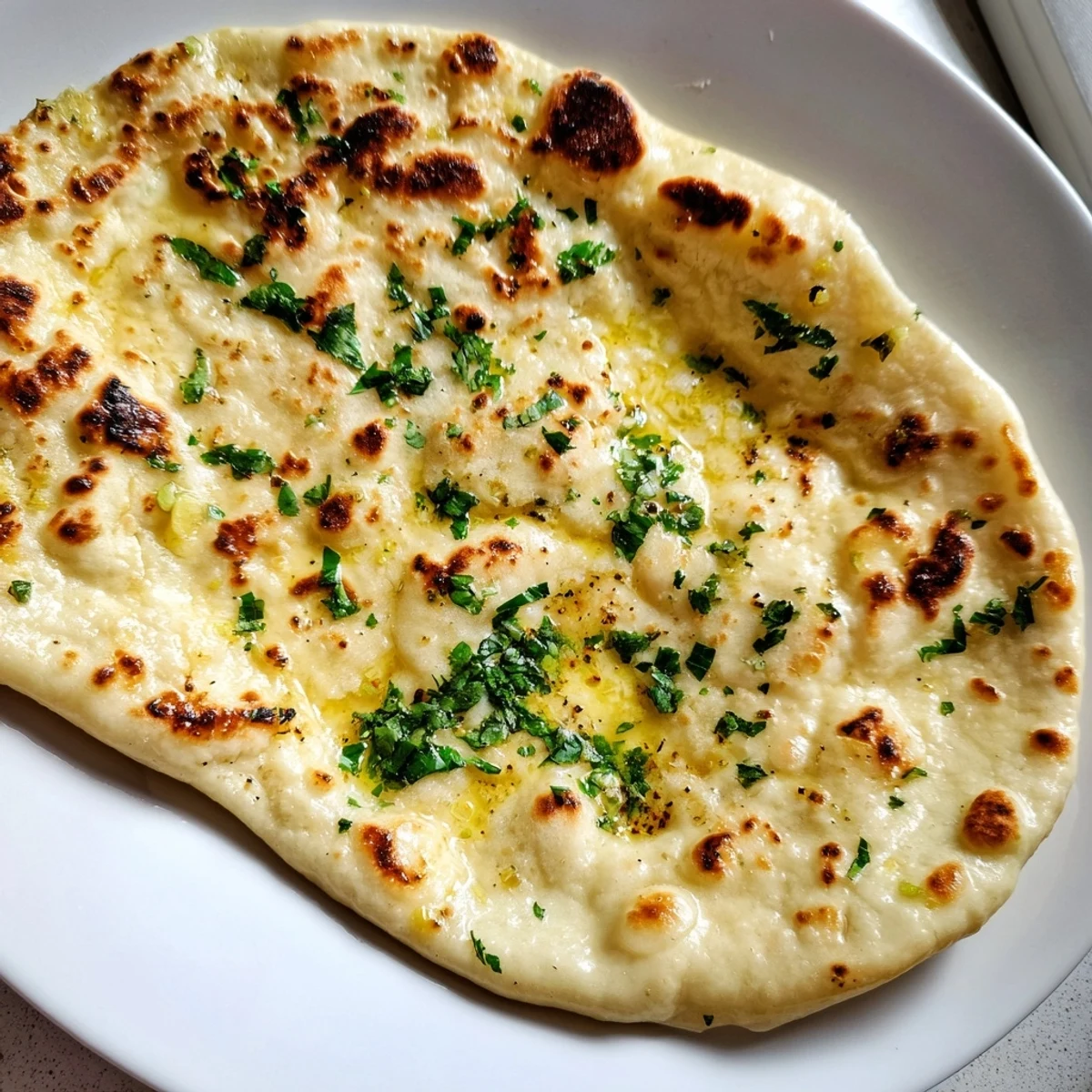 Golden-brown garlic naan, a soft and chewy Indian flatbread perfect alongside your favorite dishes.