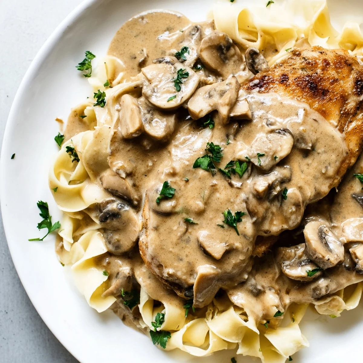 Golden-brown, pan-seared chicken breasts in a glossy, creamy Marsala and mushroom sauce served over al dente fettuccine.  