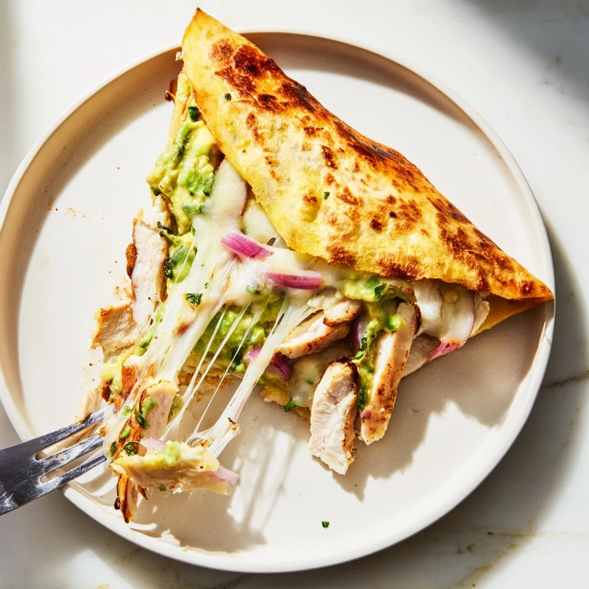 Golden brown Chicken Avocado Quesadilla wedges, filled with grilled chicken, creamy avocado, and melted Monterey Jack cheese.