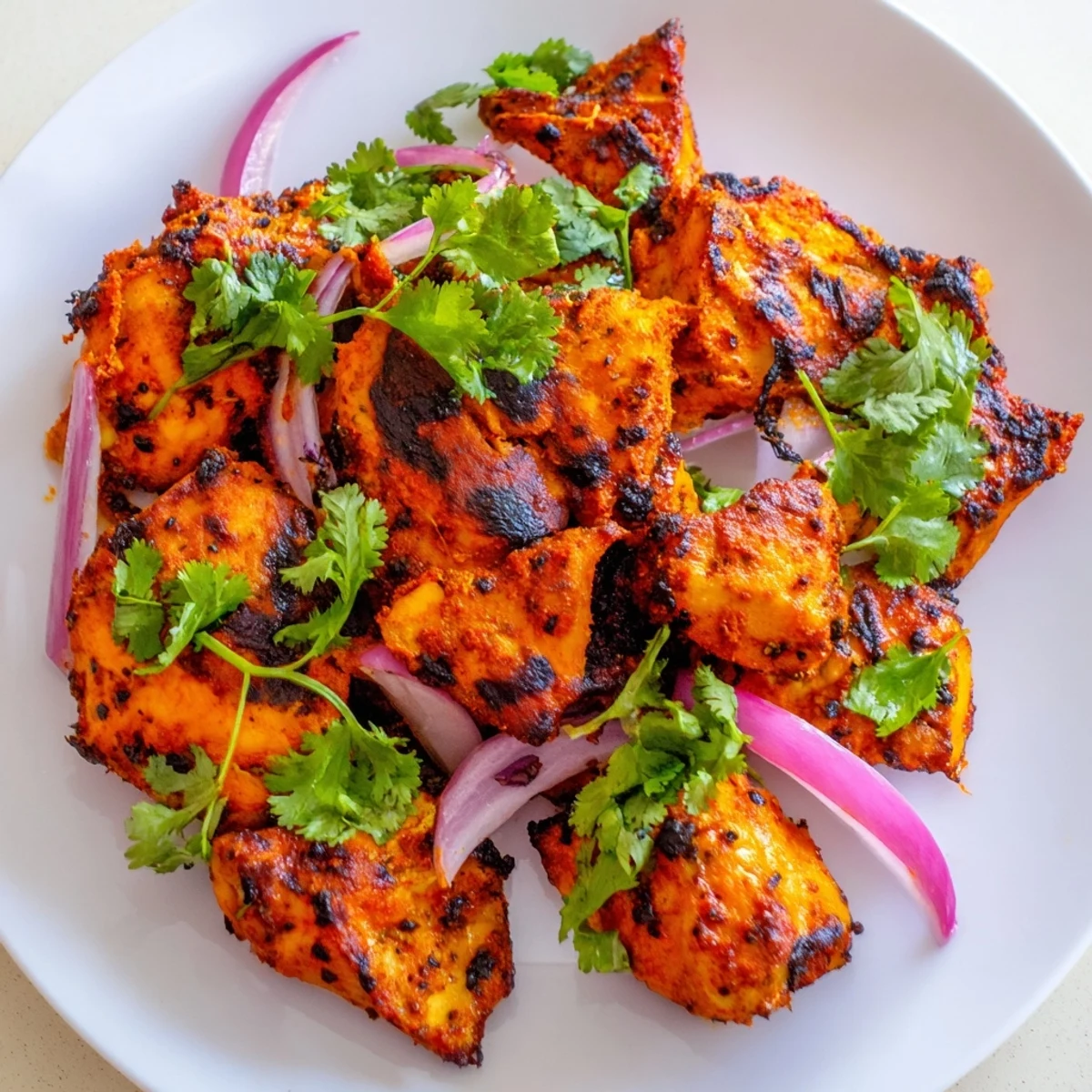 Vibrant Indian Tikka Spiced Chicken thighs with a crispy char, served hot alongside fluffy basmati rice and warm naan bread.  