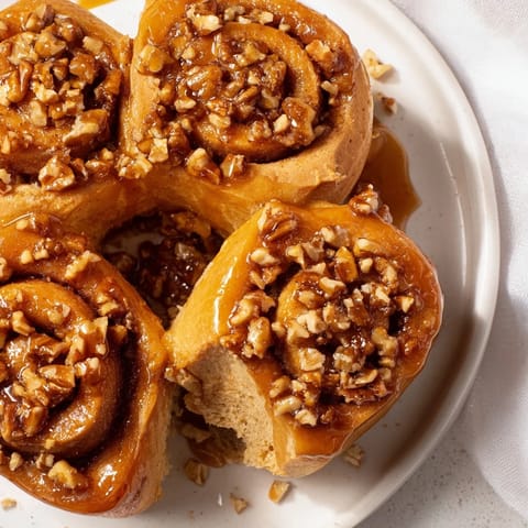 Warm, gooey Maple Pecan Sticky Buns, invitingly topped with pecans and a rich, sweet glaze.