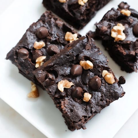 A plate of gluten-free black bean brownies, with a rich, dark chocolate aroma inviting everyone to taste.