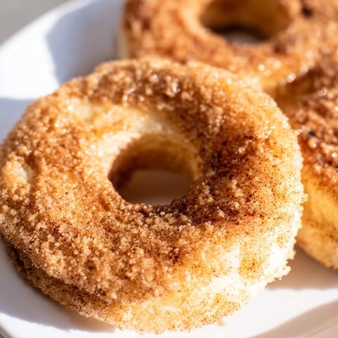 Warm, buttery 1-Minute Air Fryer Donuts with a delightful cinnamon sugar coating make the perfect dessert.