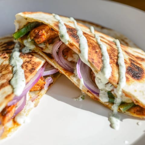 Golden-brown Tandoori Chicken Quesadilla, filled with melted cheese and tender, spiced chicken.