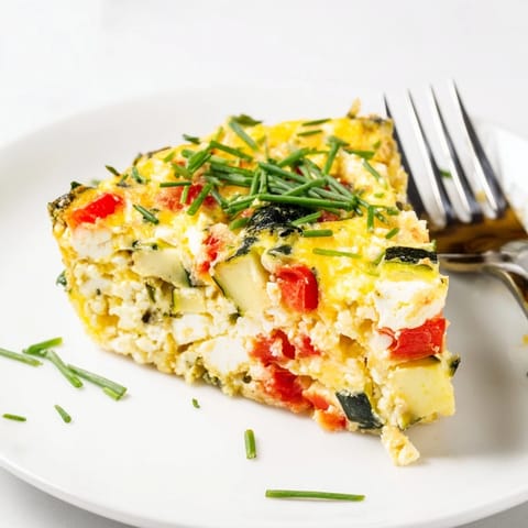 High-protein sheet pan eggs with cottage cheese and veggies, cut into squares on a white plate for meal prep.  