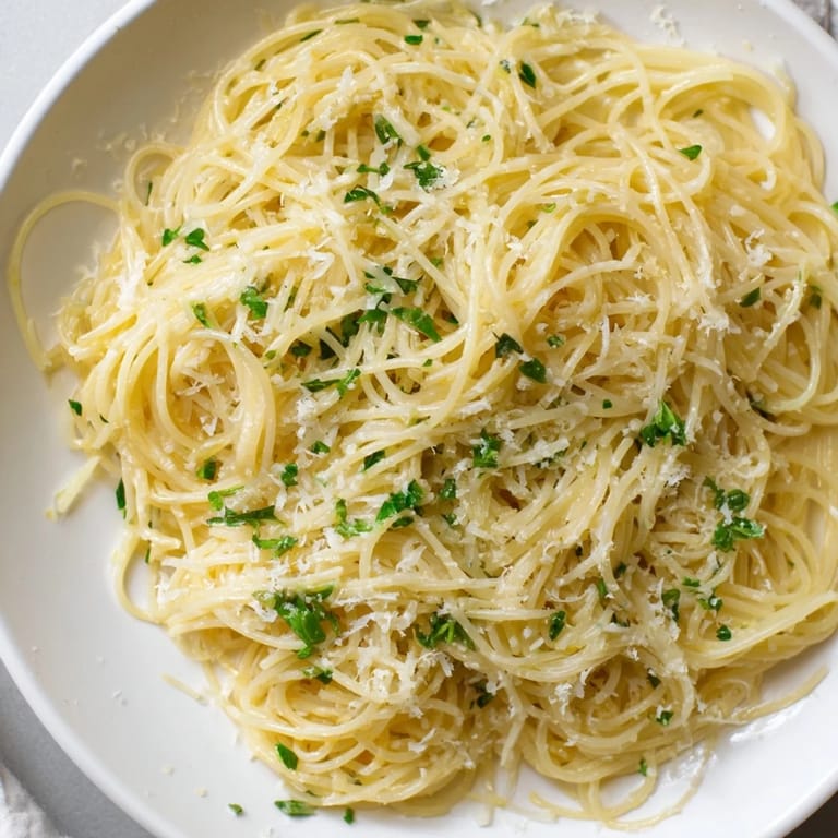 A close-up view of Lemon Capellini, showcasing vibrant herbs and a creamy, delicious sauce.