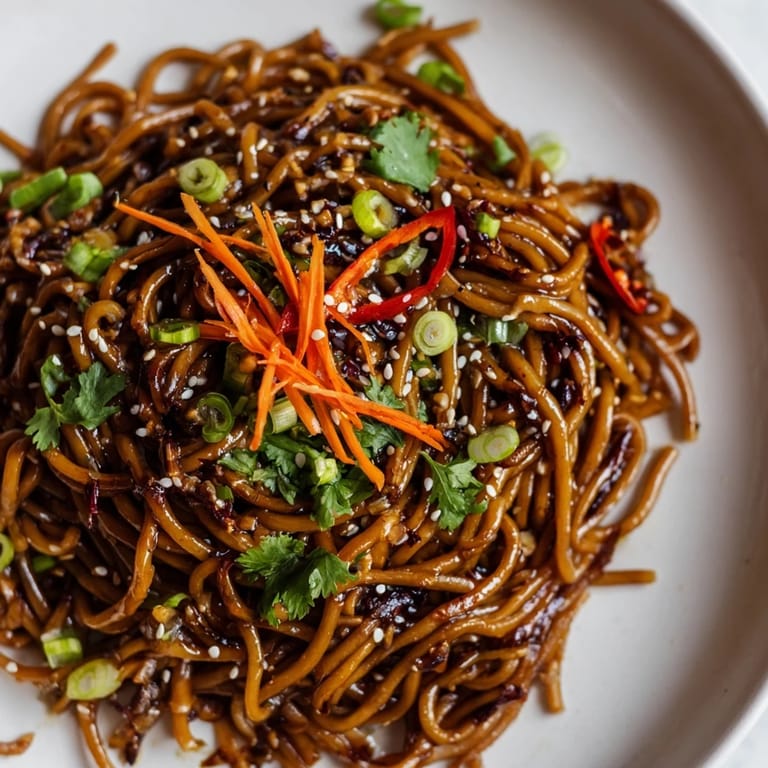 Freshly prepared Asian Garlic Noodle Bowl served with julienned carrots and cilantro, perfect for a quick and flavorful weeknight dinner.