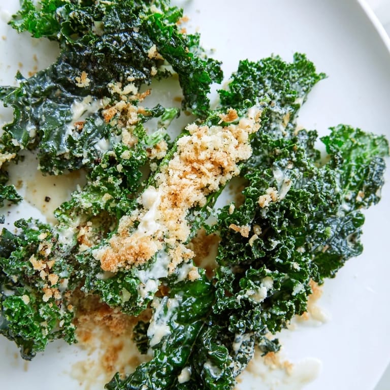 A vibrant bowl of Garlic Parmesan Kale Salad with tender leaves, creamy dressing, and crispy breadcrumbs for extra texture.