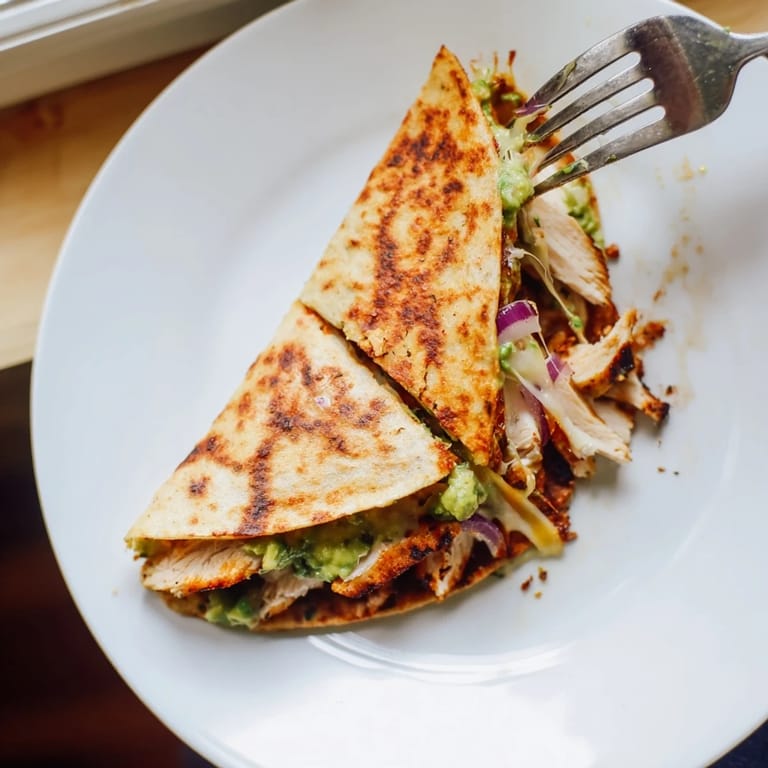 Freshly grilled Chicken Avocado Quesadilla served warm with a side of zesty salsa and sour cream.
