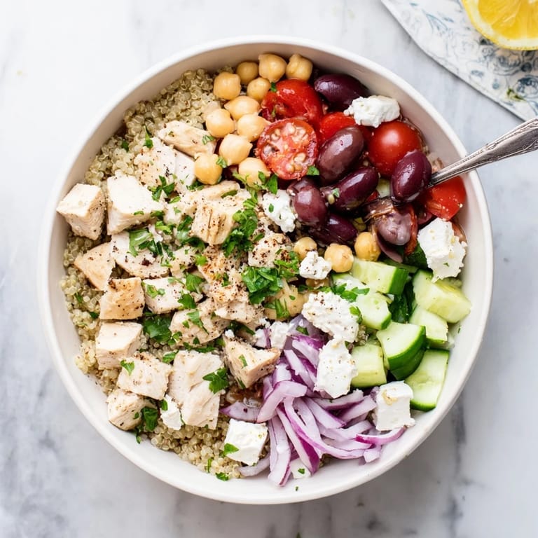 Easy Mediterranean Chicken Bowl with golden chicken, quinoa, and crisp vegetables, drizzled with tangy lemon dressing.