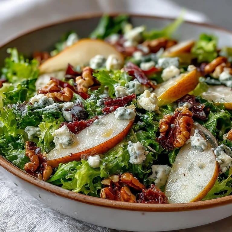 Tangy vinaigrette glistens on the Frisée Pear Blue Cheese Bowl with sliced pears and greens.